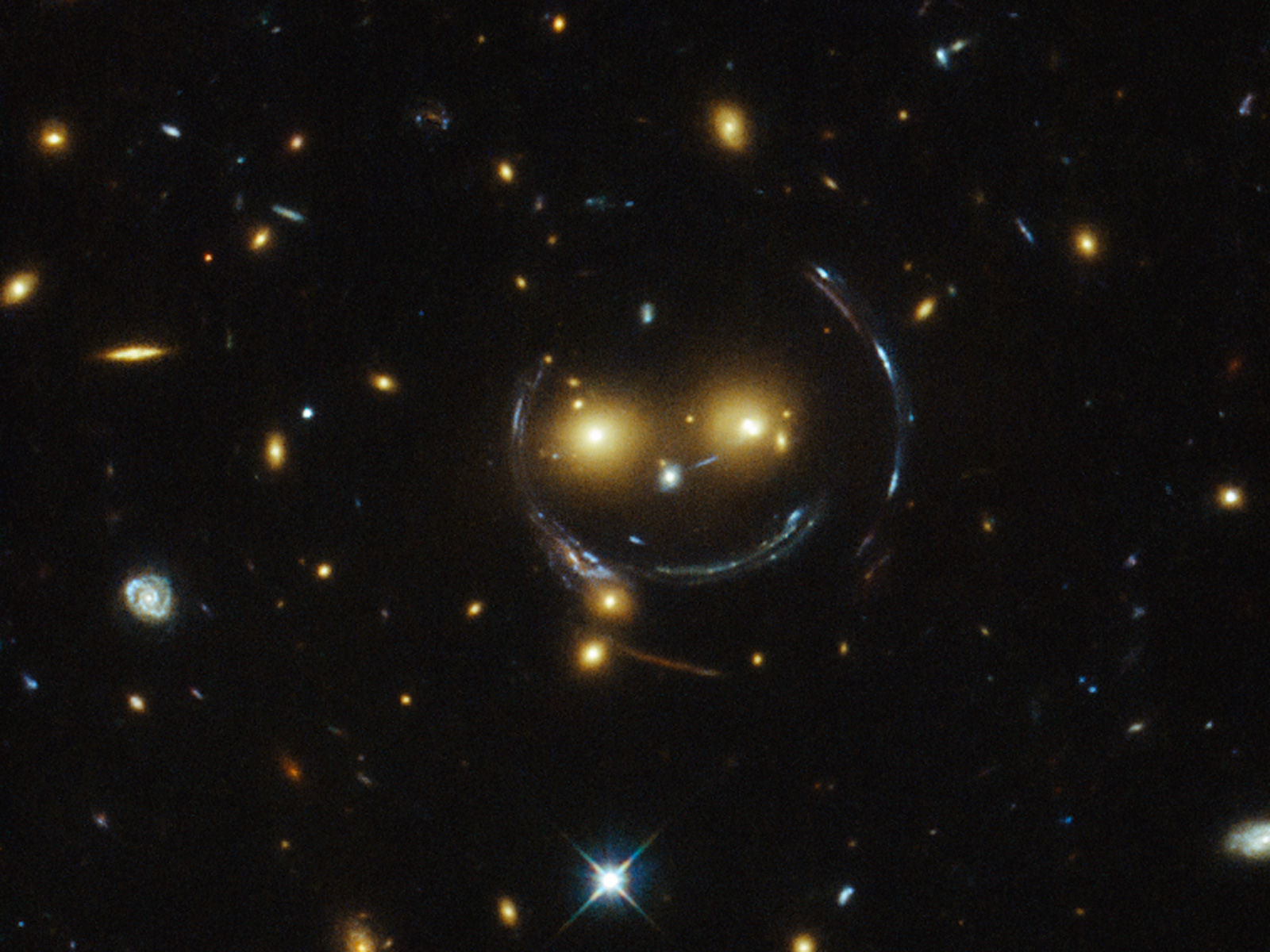 Hubble v um aglomerado de galxias que se parece com um macio Smiley