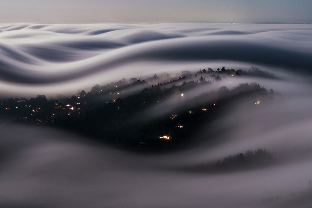 Impressionante foto de aldeia coberta com a névoa iluminada por lua cheia